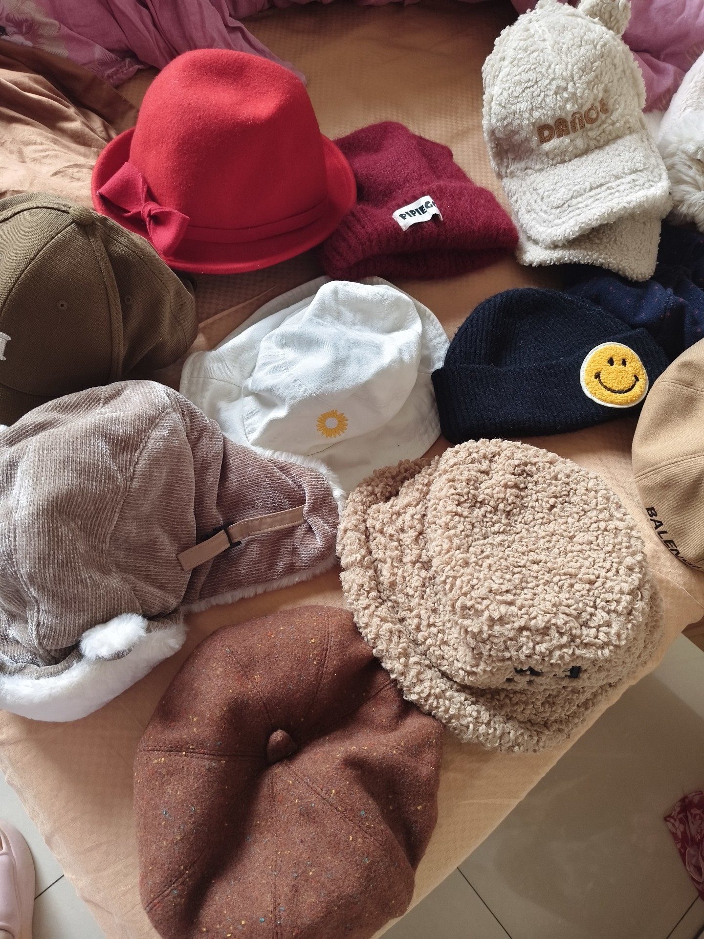 ​一堆帽子，有红色、酒红、白色、卡其色等多款，都是秋冬款的
