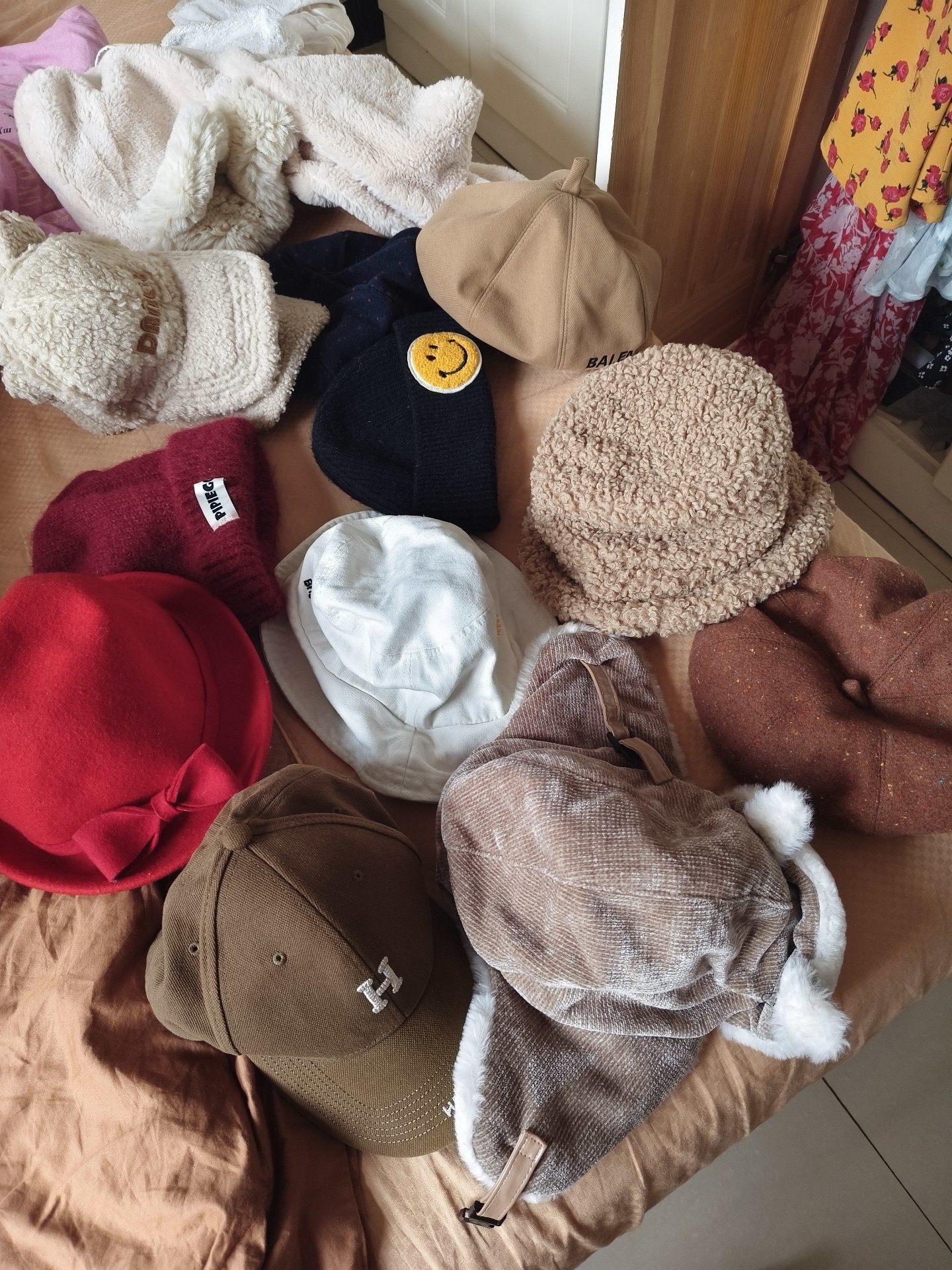 ​一堆帽子，有红色、酒红、白色、卡其色等多款，都是秋冬款的