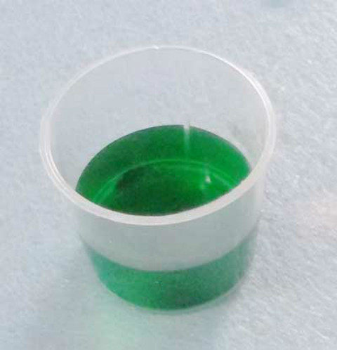 把量杯中带色素的水轻轻倒入到混合材料的小碗里,     边搅拌边倒水