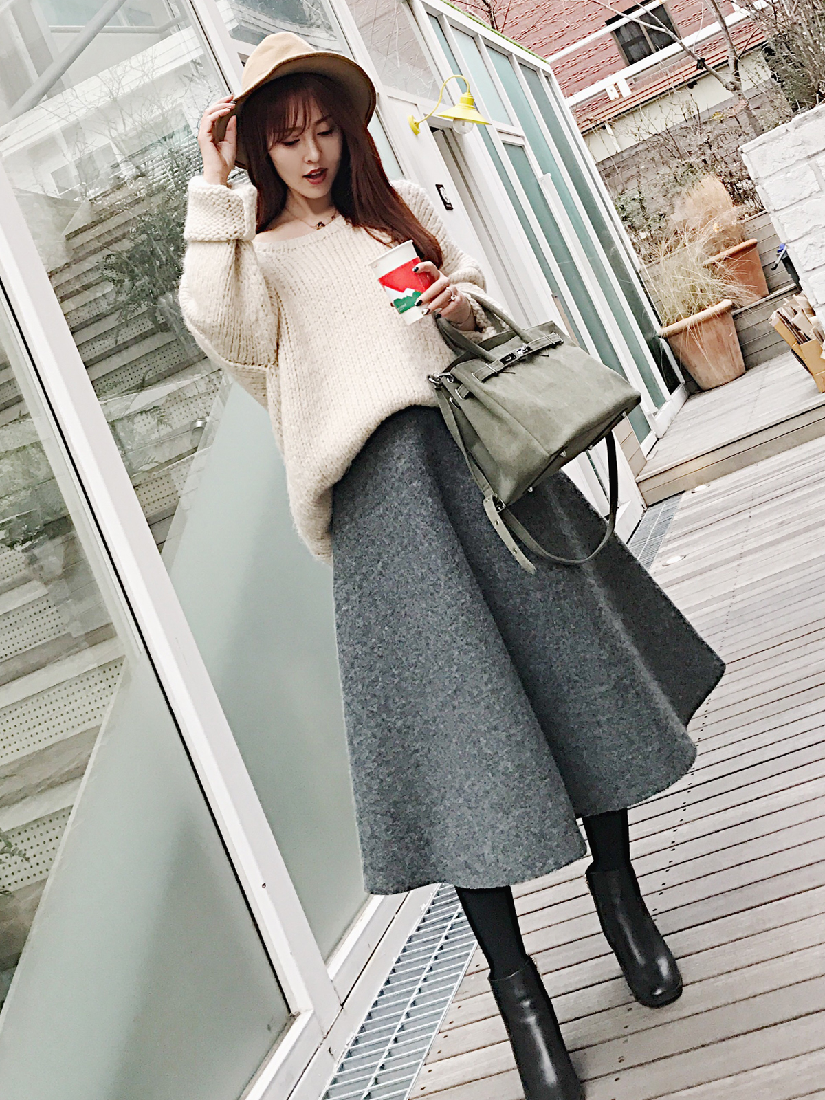 浅米色的宽松款毛衣搭配这条高腰a字摆呢料裙,甜美又不失大气.