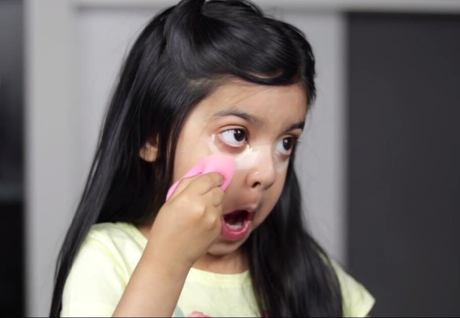 接着,她很干脆利落地在她的黑眼圈上涂上了一大笔遮瑕液,用海绵蛋轻轻