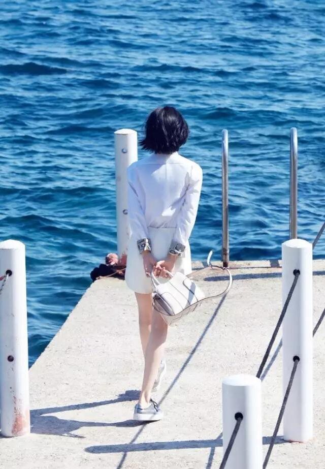 衬衫搭配白裙,和海景融为一体,光是一个背影就已经美得引起人无限遐想