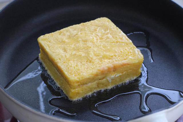 6.平底锅放少量食用油烧热,将裹满蛋液的吐司放入锅中用小火煎制.