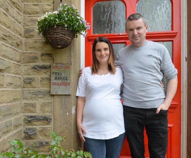 图为正在怀孕中的妈妈和这个家庭的爸爸.看起来,他们都很幸福.