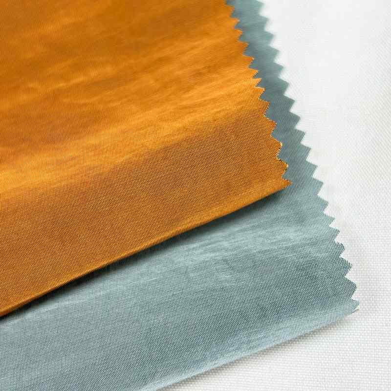 现货梭织70g尼龙双色金属羽绒服起皱防水丝面料防晒黑尼丝纺棉服