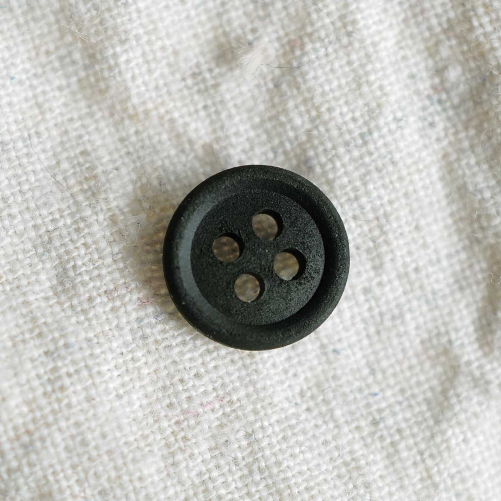 泛绿的黑底棉主材质纽扣