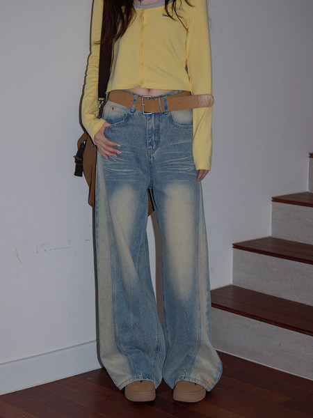 Model wearing faded blue wide-leg jeans with a yellow cardigan