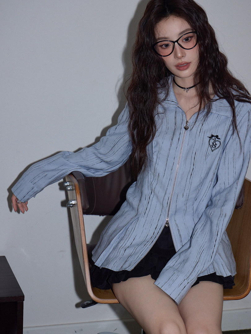 Model wearing a light blue zip-up jacket with long sleeves