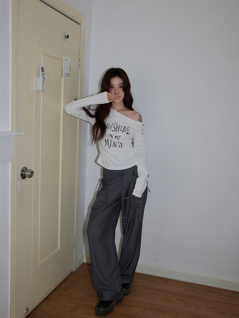 Model wearing a white off-shoulder long-sleeve top and dark wide-leg pants