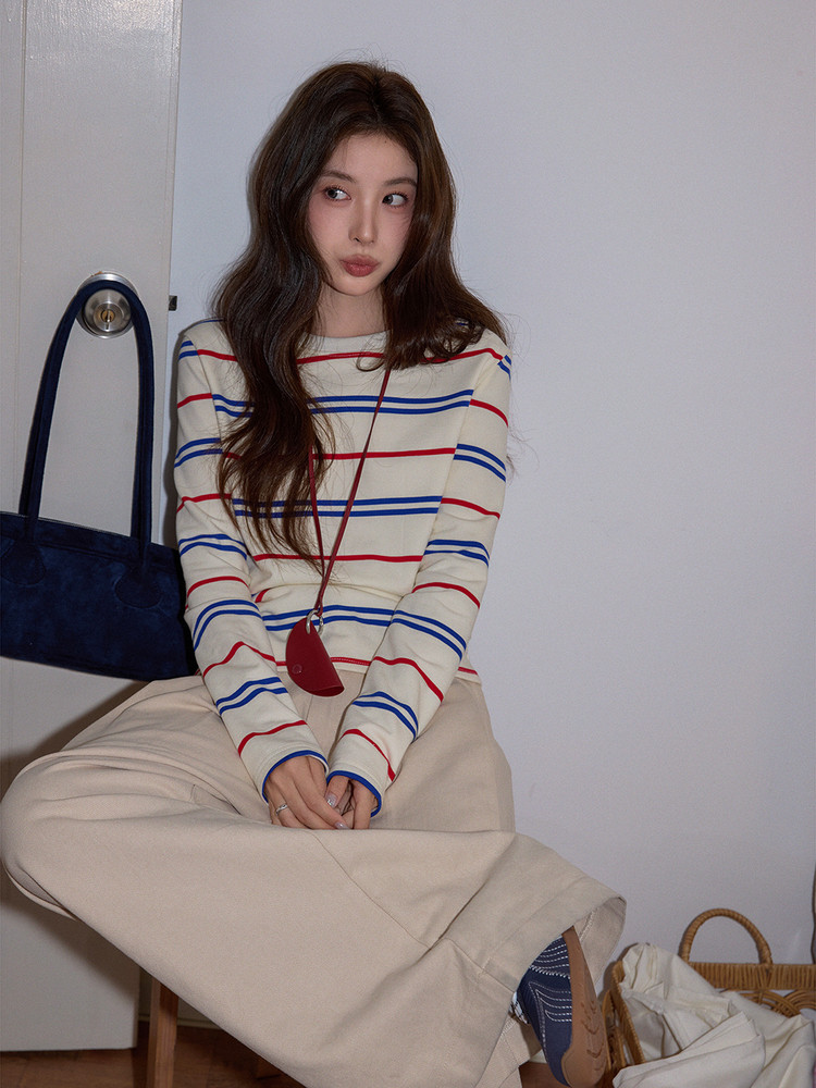 Model wearing a striped long-sleeve top and cream wide-leg pants