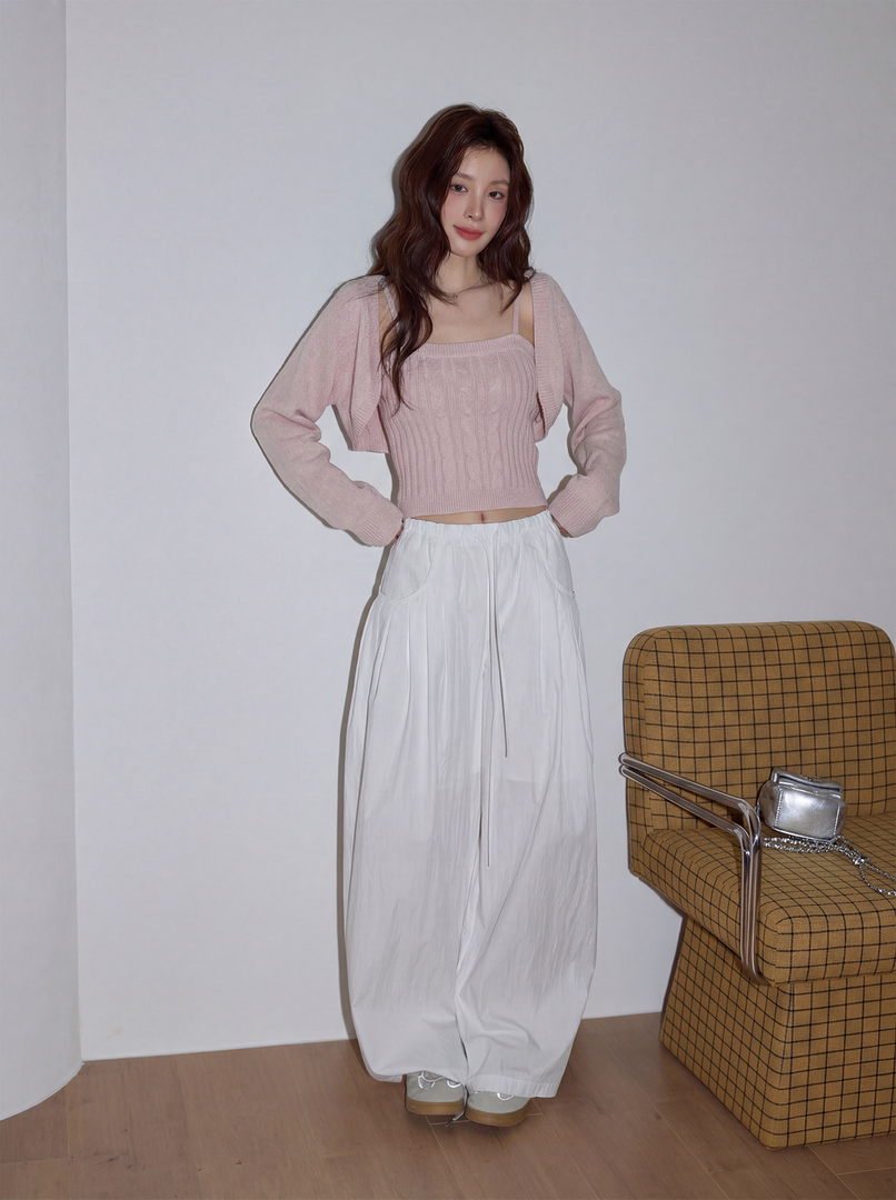 Model wearing a pink knit cardigan and top with white wide-leg pants