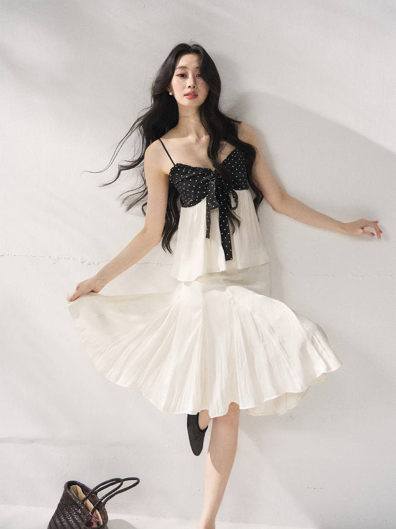 Model wearing a black polka dot and cream chiffon dress