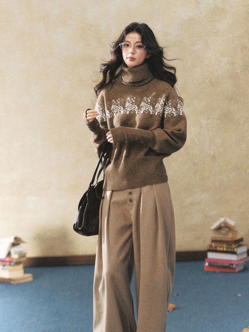 Model wearing a brown turtleneck sweater with a winter pattern and wide-leg beige pants
