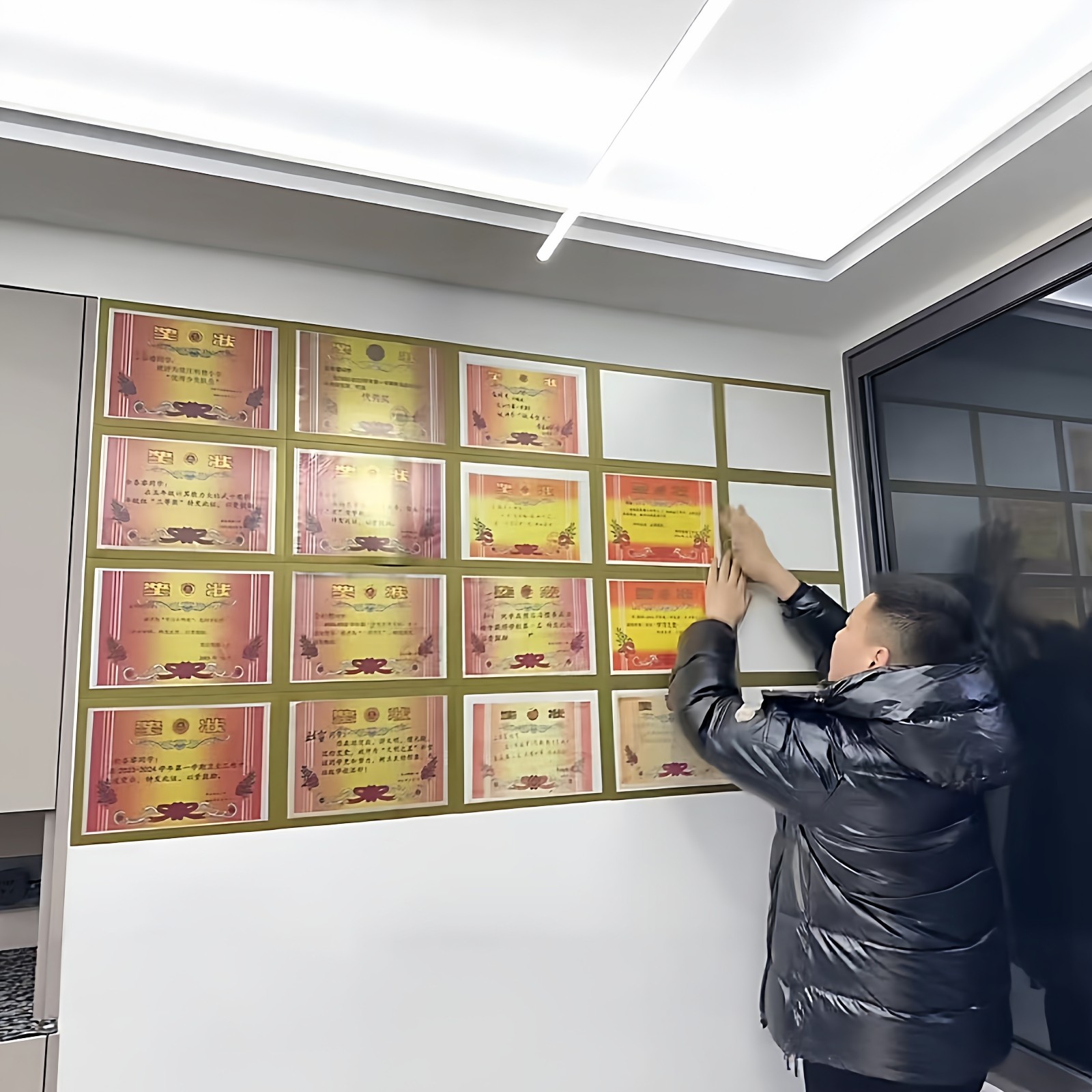 让学生的荣誉奖状挂遍整墙相框
