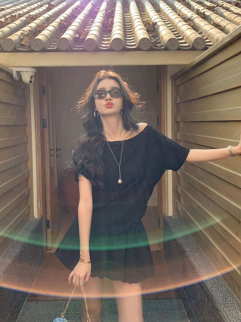 Woman wearing a black off-shoulder mini dress outdoors