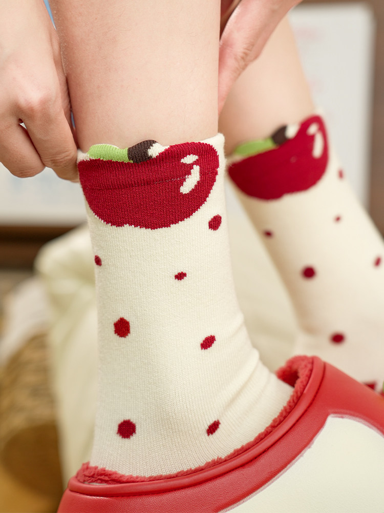 Close-up of cream socks with red polka dots and red trim being worn