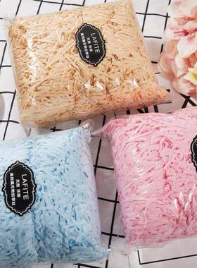 gift lined with shredded paper filling colored packing box