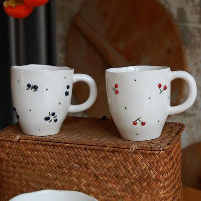 Cherry patterned ceramic tea cups, dessert bowls, and plates