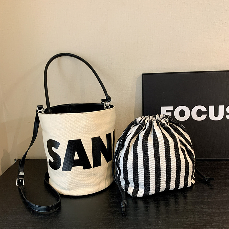 包2025大容量字母帆布撞色百搭小众单肩抽绳斜挎水桶包