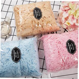 gift lined with shredded paper filling, colored packing box