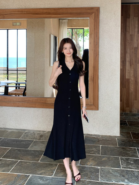 Woman wearing a black sleeveless button-front midi dress