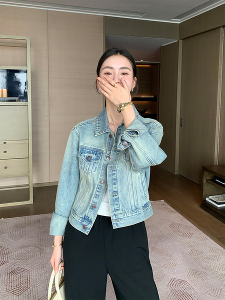 Light blue denim jacket worn by a model with black pants