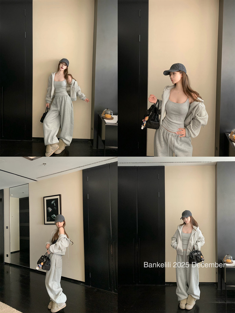 Model wearing a gray loungewear outfit with striped hoodie, tank top, sweatpants, cap, and boots