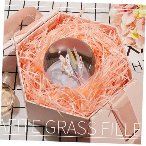 gift lined with shredded paper filling colored packing box