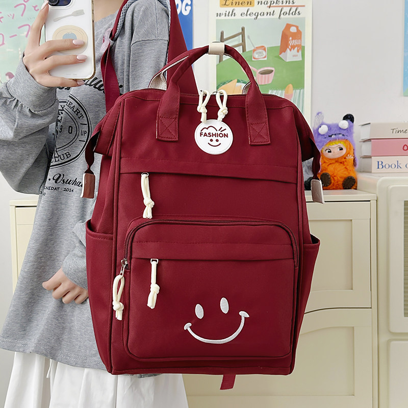 红色笑脸书包女生大学生简约百搭手提电脑包韩版高中生通勤双肩包