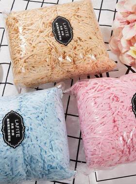 gift lined with shredded paper filling, colored packing box