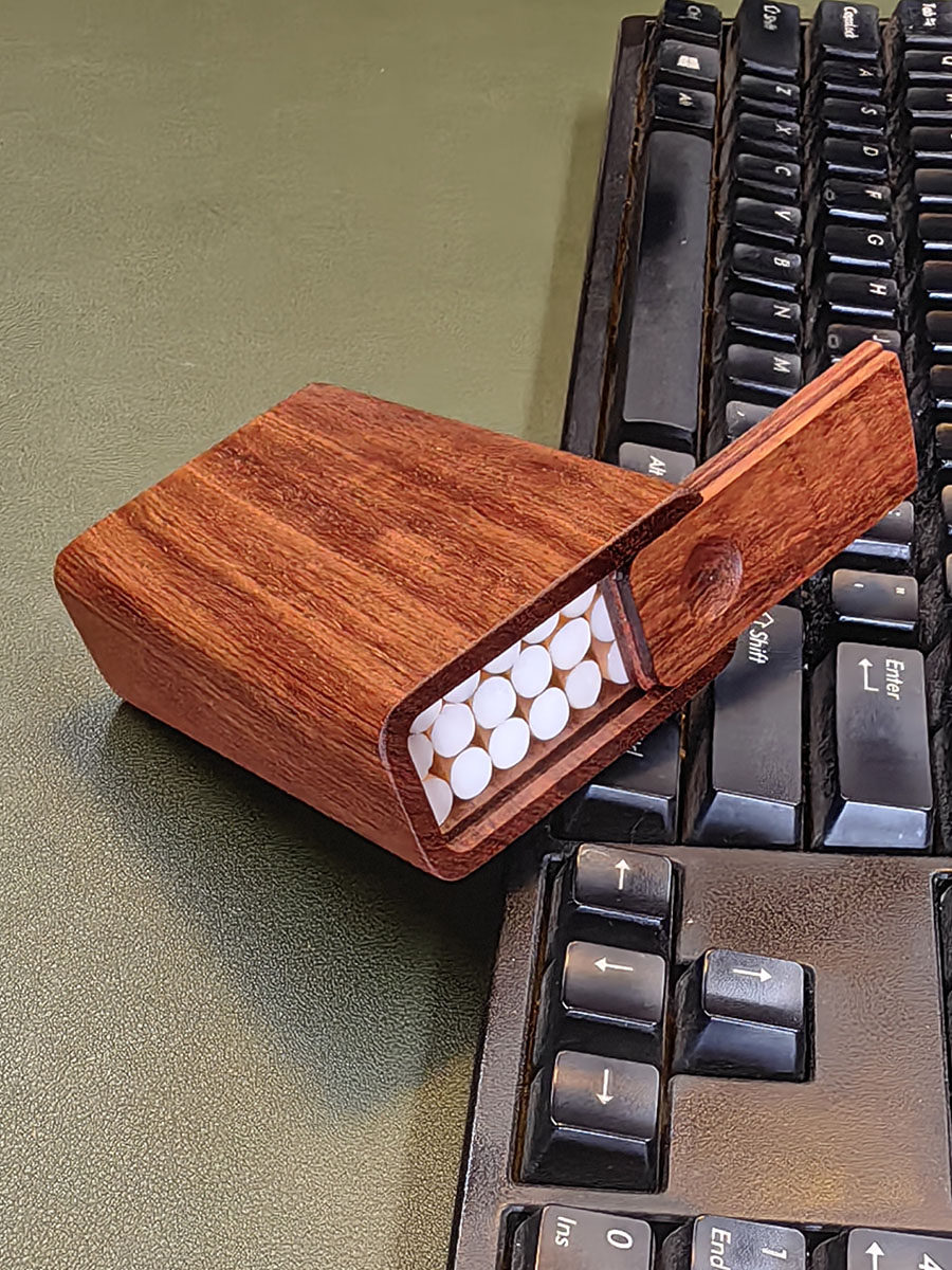 무지탕 설탄[MUZITANG XUETAN]은 속이 빈 조잡한 담배를 손으로 말아서 만든 견고한 목재 휴대용 담배 케이스로 라이터를 담을 수 있는 플립탑 뚜껑이 있습니다