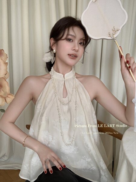 White halter-neck sleeveless top worn by a model
