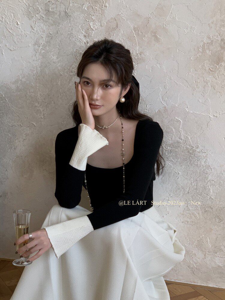 Model wearing a black-and-white elegant long-sleeve dress set