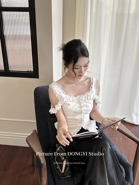 White ruffled sleeveless top worn by a model