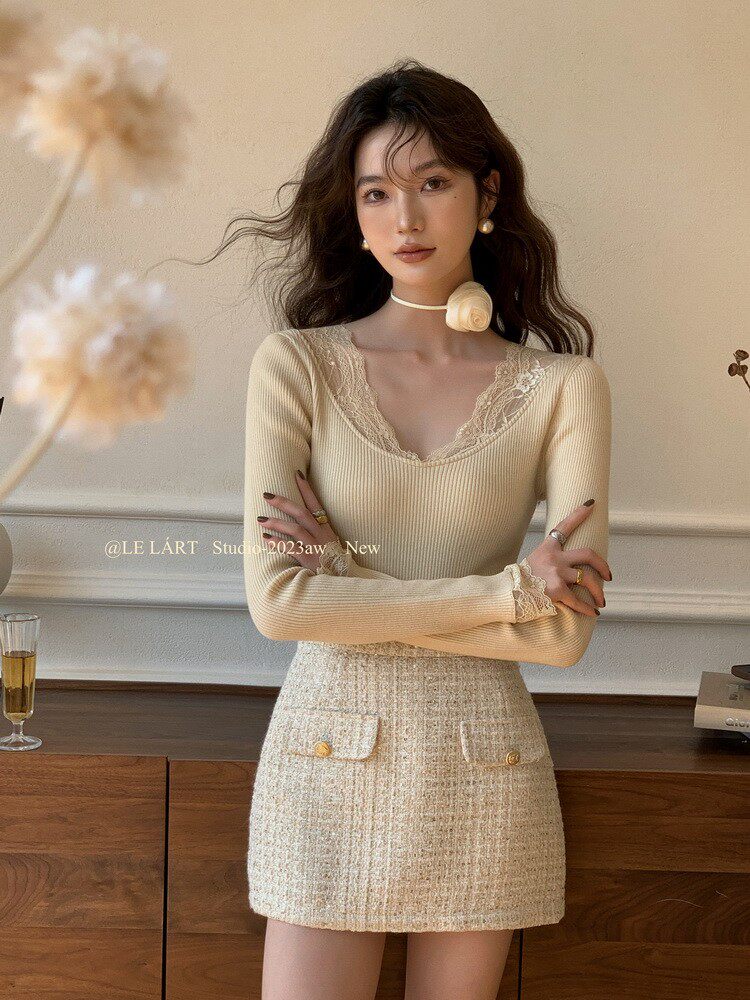 Model wearing a beige lace-trim knit top with a tweed mini skirt