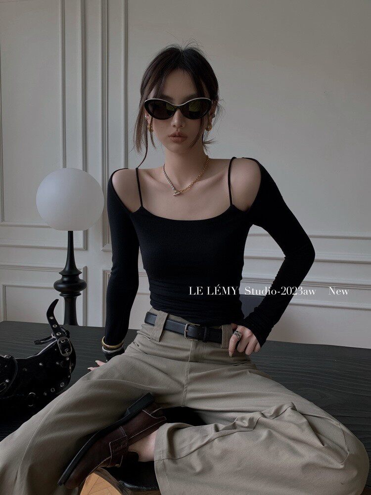 Model wearing a black long-sleeve fitted top with beige wide-leg pants and sunglasses
