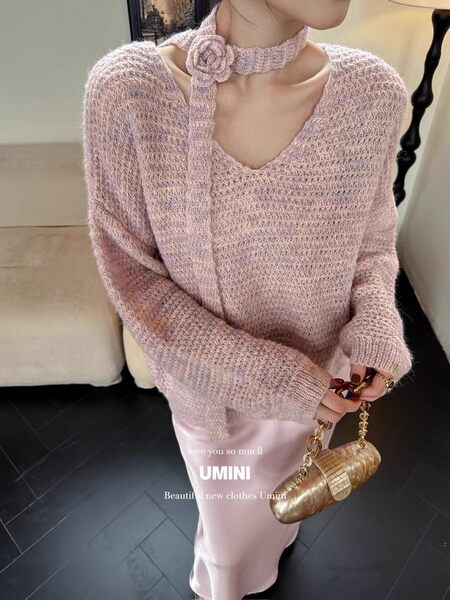 Model wearing a soft pink fuzzy knit sweater with a matching skirt and chain handbag