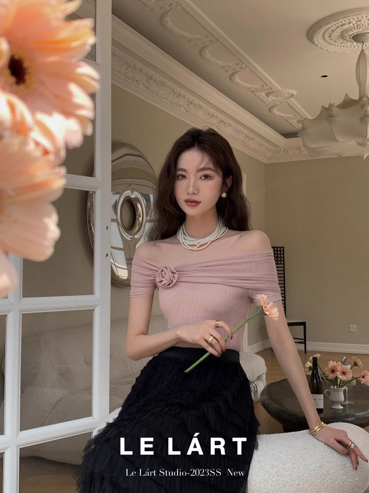 Model wearing a pink off-shoulder top with a black skirt