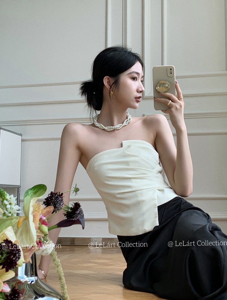 Woman wearing a strapless white top with a black skirt