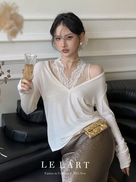 Woman wearing a white lace-trim off-shoulder top with a gold belt and long skirt