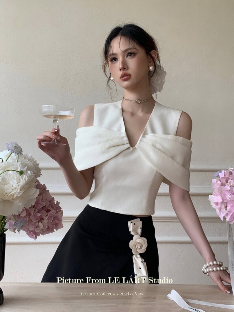 Model wearing a white off-shoulder top with a black skirt