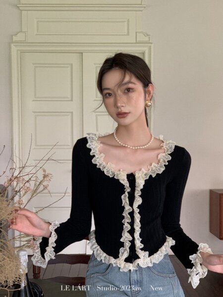 Black long-sleeve ruffled lace-trim top worn by a model with jeans