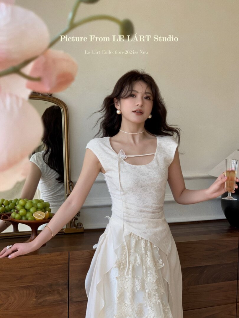 White sleeveless lace dress worn by a model indoors