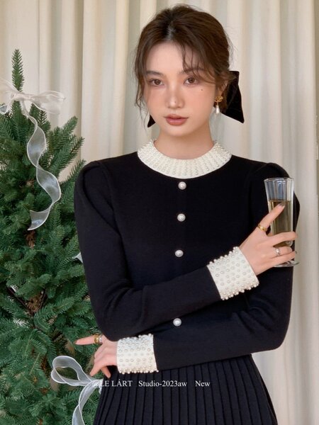 Black long-sleeve pearl-trim dress worn by a model