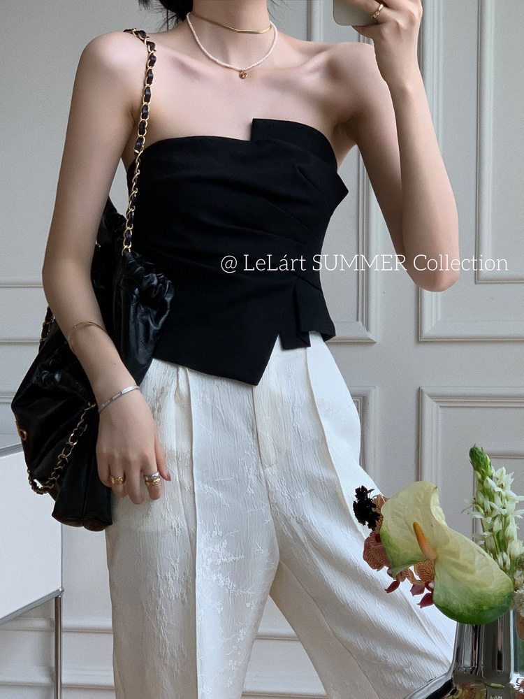 Model wearing a black strapless top with white wide-leg pants