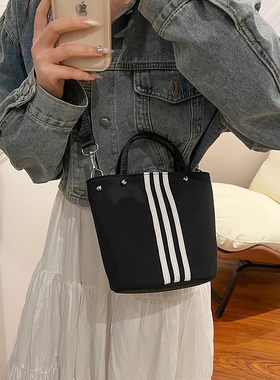 条纹撞色水桶包女2026新款手提斜挎包轻便百搭休闲黑色尼龙小包包