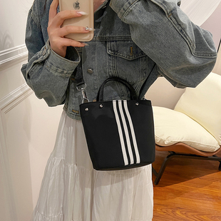 条纹撞色水桶包女2026新款手提斜挎包轻便百搭休闲黑色尼龙小包包