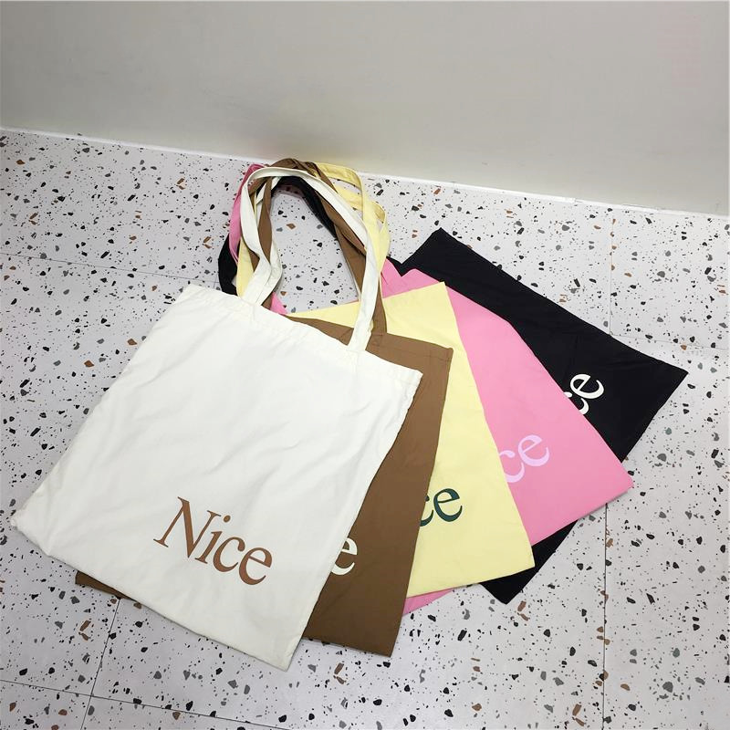 小脏柜 2025夏季新款马卡龙色尼龙布包包轻便休闲百搭Nice字母包