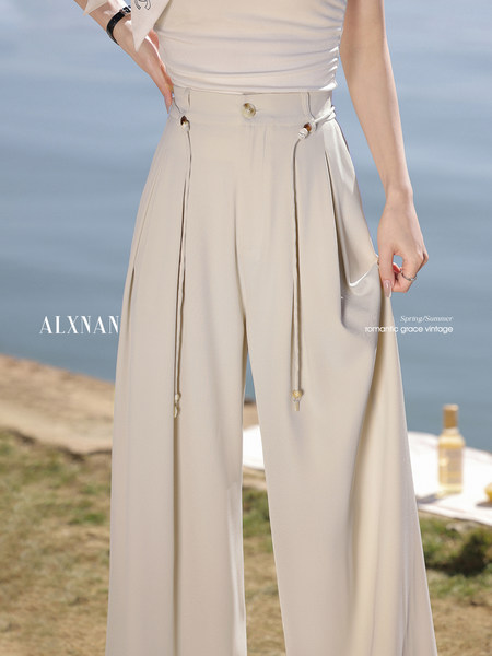 Beige wide-leg pants worn by a model outdoors by the seaside