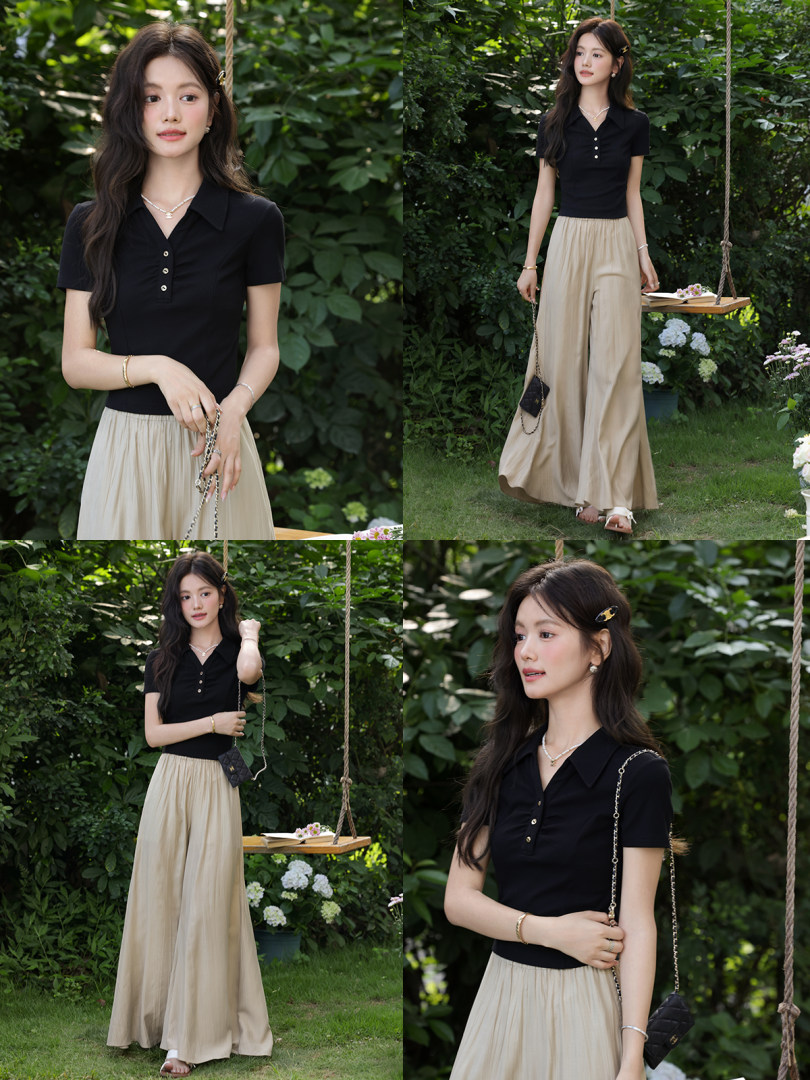 Model wearing a black short-sleeve polo top with a beige wide-leg skirt or pants outdoors